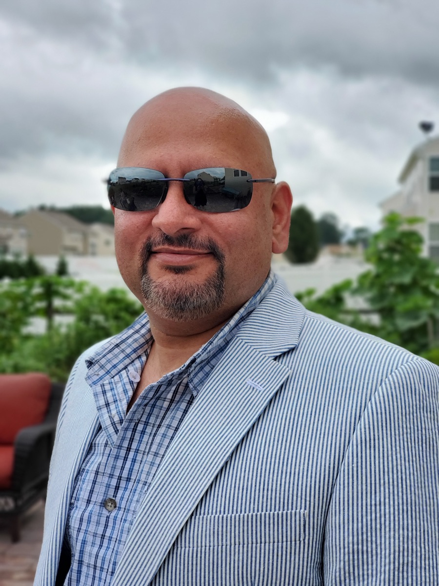 KJ Dhami wearing sunglasses and a light blazer